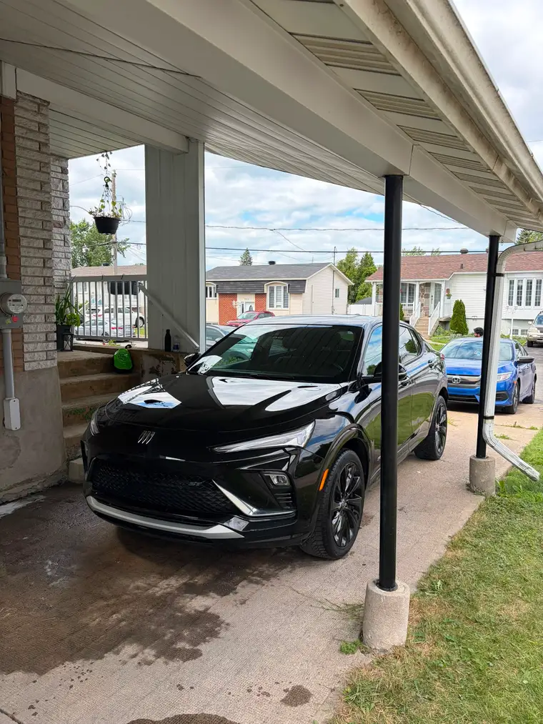 Black Buick Envista ST with mirror-gloss paint after a mobile detail under a carport